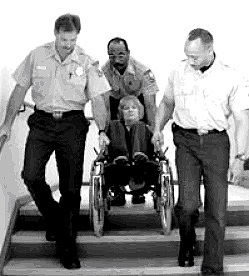 Emergency_personal_carrying_wheelchair_down_stairs